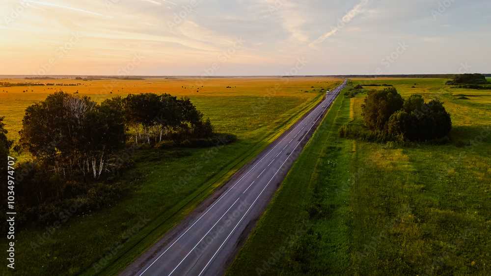 Fototapeta premium Trucks are driving along the highway at a beautiful dawn