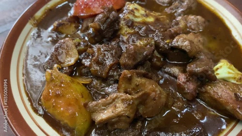 Tongseng delicious food served on a plate. Goat meat stew cooked with sweet soy sauce, coconut milk, sliced ​​cabbage, and tomatoes. Commonly found in Central Java, from Surakarta to Yogyakarta. photo