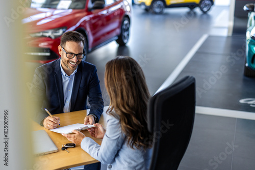 Customer buyer client wear shirt sign paper contract document with salesman choose auto want buy new automobile in car showroom vehicle salon dealership store motor show. Sales concept photo