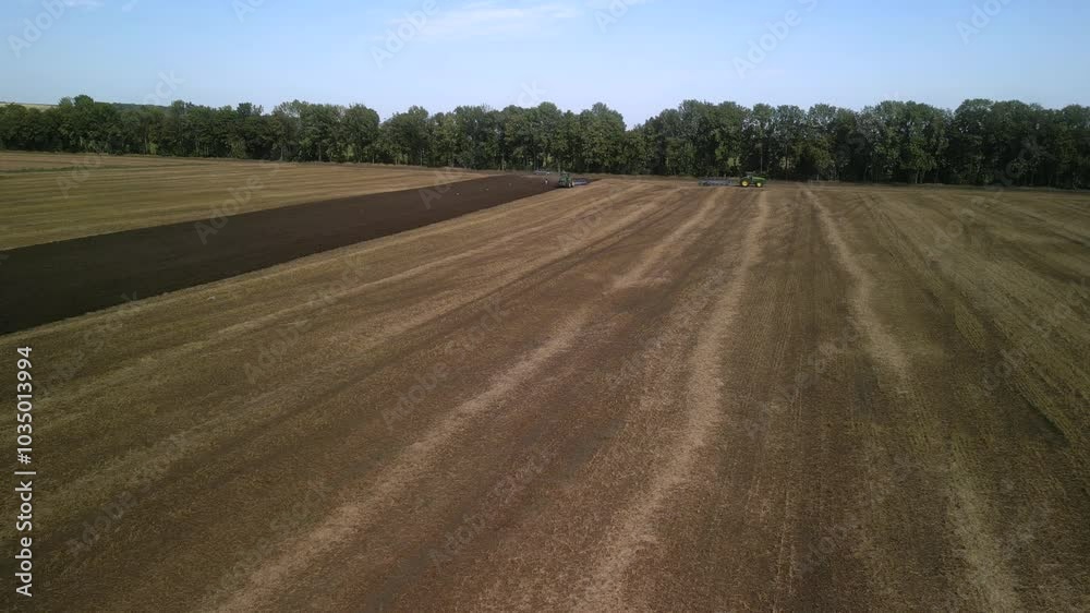 Aerial View of Tractor Plowing Farmland. Tractor and Plow Turning the Soil Aerial View of Tractor Plowing Farmland. Tractor and Plow Turning the Soil