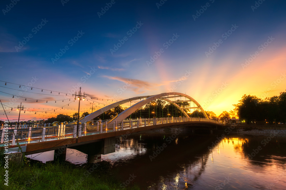 Fototapeta premium light Bridge over the Nan River (Wat Phra Si Rattana Mahathat also - Chan Palace) New Landmark It is a major tourist is Public places attraction Phitsanulok,Thailand.vivid Twilight dramatic sunset.