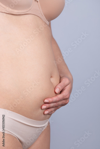 Wallpaper Mural Woman in underwear on profile, with swollen belly and a hand on it. Concept of woman, swelling and discomfort Torontodigital.ca