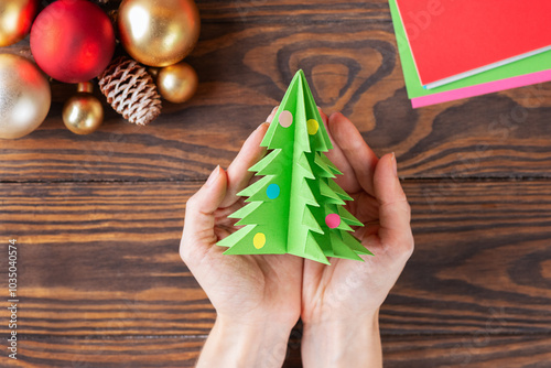 Step-by-step Christmas tree handmade paper toy. The final result of the tree made of colored paper. Top view.