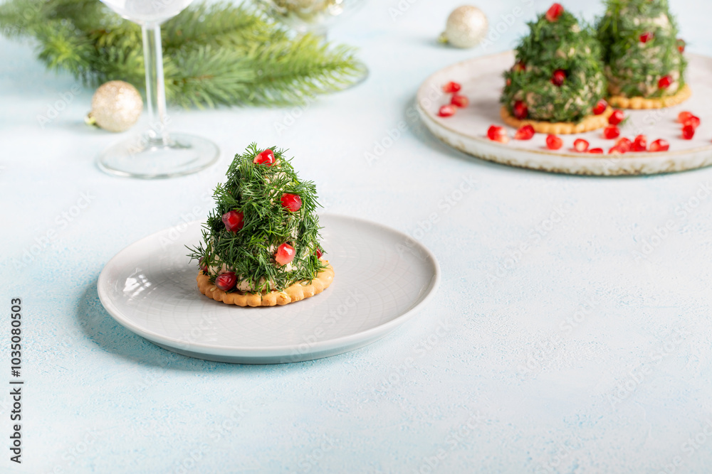 Portioned tuna pate on cracker decorated with dill and pomegranate seeds. Christmas appetizer in shape of Christmas tree. Portioned tuna pate on cracker decorated with dill and pomegranate seeds. Christmas appetizer in shape of Christmas tree.