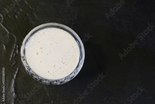 Delicious homemade mayonnaise sauce. Glass gravy boat with mayonnaise on a dark background with copy space. photo