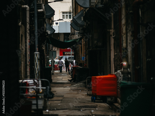 Fototapeta Naklejka Na Ścianę i Meble -  Dark and cluttered street with people at the end of it from Hong Kong, China