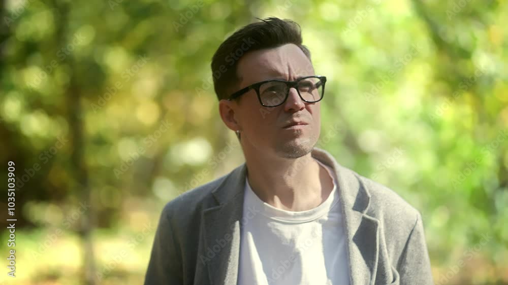 A young man stands thoughtfully in a lush green environment, showcasing contemplation amidst nature. A young man stands thoughtfully in a lush green environment, showcasing contemplation amidst nature.