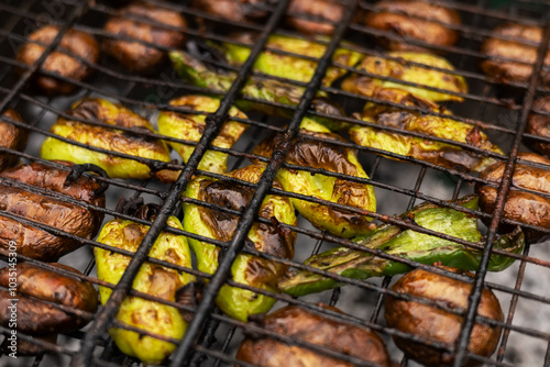 Grilled mushroom slices and pepper on a grill grate photo