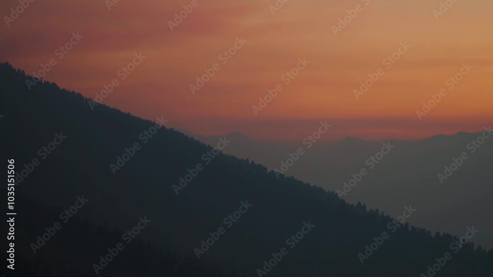 Silhouette shot of foggy Himalayan mountain ranges with orange sky during the sunset in winter season as seen from above the mountains at Kullu in Himachal Pradesh, India. Sunset at Himalayan mountain Silhouette shot of foggy Himalayan mountain ranges with orange sky during the sunset in winter season as seen from above the mountains at Kullu in Himachal Pradesh, India. Sunset at Himalayan mountain