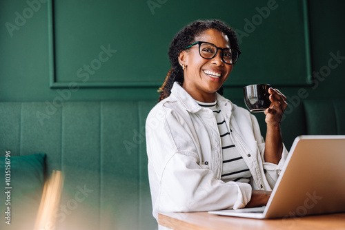 Woman smiling while working with laptop in a cafe