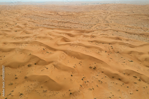 Aerial view of vast desert sand dunes with serene patterns and textures, Hamraniyah, United Arab Emirates. photo