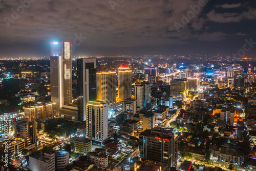 Aerial view of vibrant cityscape illuminated at night with modern skyscrapers and bustling streets, Westlands, Nairobi, Kenya.