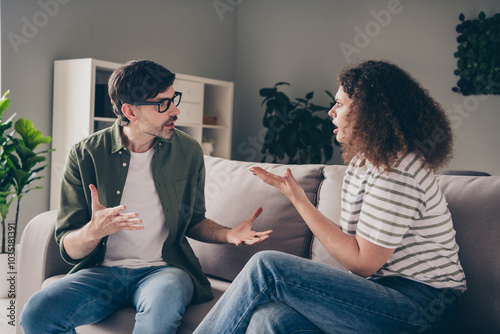 Portrait of two young partners sit sofa talk complain living room flat indoors photo