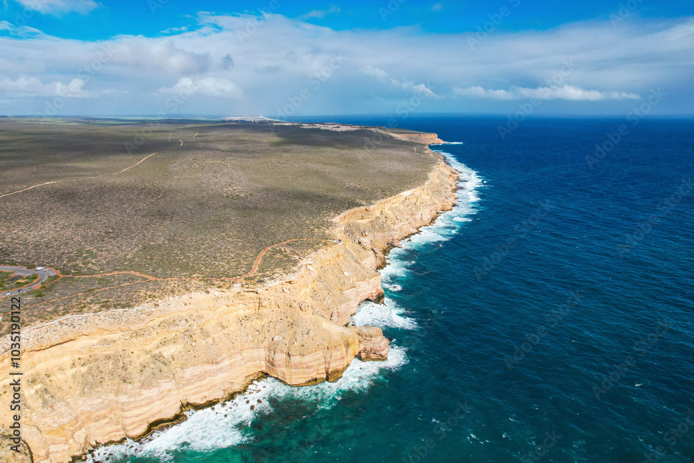 Aerial view of dramatic cliffs and serene ocean waves at Castle Cove lookout, Kalbarri National Park, Western Australia. Aerial view of dramatic cliffs and serene ocean waves at Castle Cove lookout, Kalbarri National Park, Western Australia.