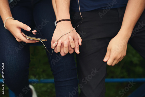 Holding hands, music and phone with couple outdoor for listening, sharing or streaming audio closeup. Earphones, radio or sound with man and woman together for bonding or enjoyment of playlist