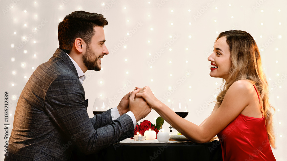 Dinner For Two. Young Man And Woman Holding Hands On Romantic Date In Restaurant, Celebrating Valentine's Day Together, Side View Dinner For Two. Young Man And Woman Holding Hands On Romantic Date In Restaurant, Celebrating Valentine's Day Together, Side View