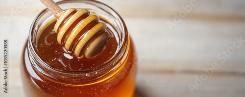 Honey jar with a wooden dipper captured from above on a white background, offering generous space for text and promotional messages