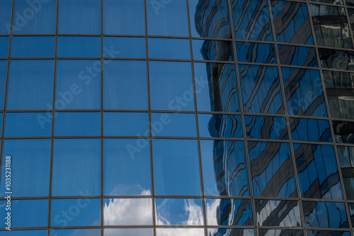 Obraz na płótnie Windows of building at sunset. Reflection of the sky in the window glass. Skyscrapers in business district against blue sky. Looking up high-rise office buildings. Angled view. w salonie
