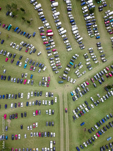 Aerial view of a parking lot filled with parked cars surrounded by green fields, West Firle, United Kingdom. photo