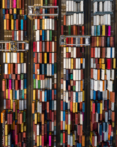 Aerial view of organized shipping containers in a colorful shipping yard with cranes, Corringham, United Kingdom. photo