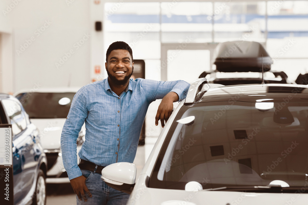 Car Buyer. Happy Afro Man Standing Posing Near New Auto In Dealership Store. Copy Space Car Buyer. Happy Afro Man Standing Posing Near New Auto In Dealership Store. Copy Space