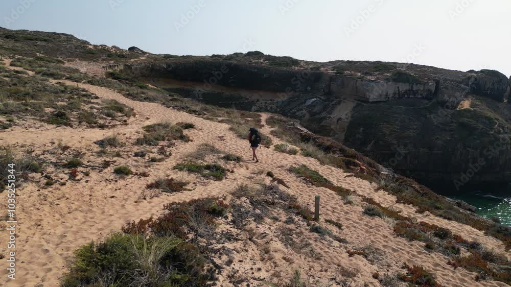 Backpacker hikes sandy section of Fisherman's Trail on Portugal coast Backpacker hikes sandy section of Fisherman's Trail on Portugal coast
