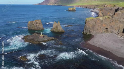 Aerial view of rugged cliffs and blue ocean waves at Skjol Fjordur, Austuland, Iceland. photo