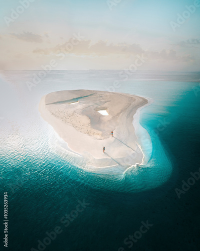 Aerial view of serene sandbar and tranquil beach at sunrise with clear turquoise water, Alif Alif Atoll, Maldives.