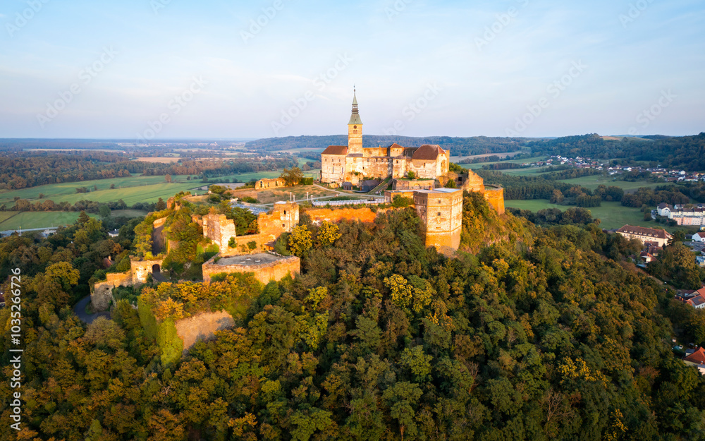 Aerial view of the beautiful Burg Guessing fortress on a hilltop surrounded by trees, Guessing, Austria.