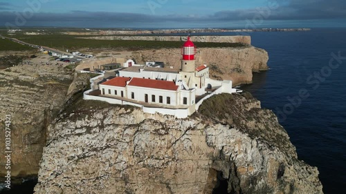 Golden hour low flight past St Vincent lighthouse atop ocean cliffs