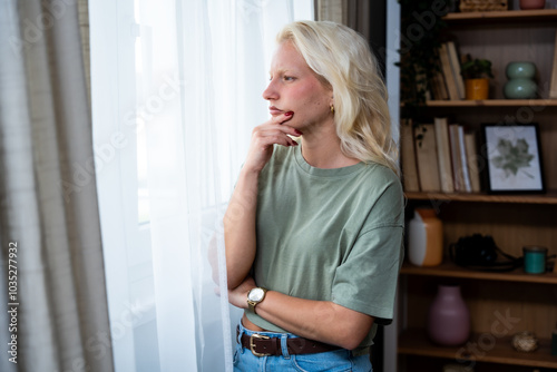 Sad pensive woman at home. Depression seasonal affective disorder mental health looking out the window alone. Introvert self isolation from people. Depressed female suffering from anxiety.