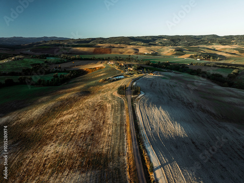 Aerial view of beautiful rolling hills and vineyards at sunset, San Quirico d'Orcia, Italy.