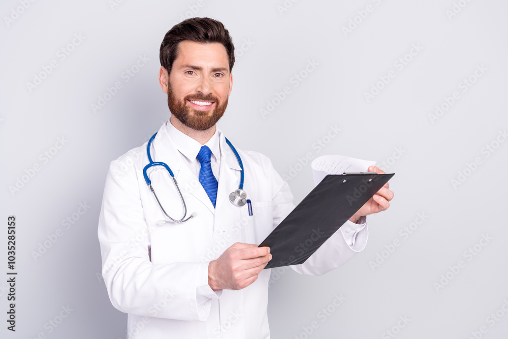 Photo of man doctor qualified specialist wear uniform hold checklist reading diagnosis isolated on grey color background Photo of man doctor qualified specialist wear uniform hold checklist reading diagnosis isolated on grey color background