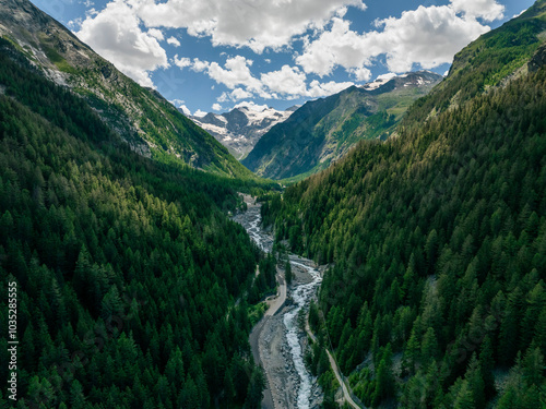 Aerial view of lush green valley with a serene river and majestic mountains, Gran Paradiso National Park, Cogne, Italy. photo