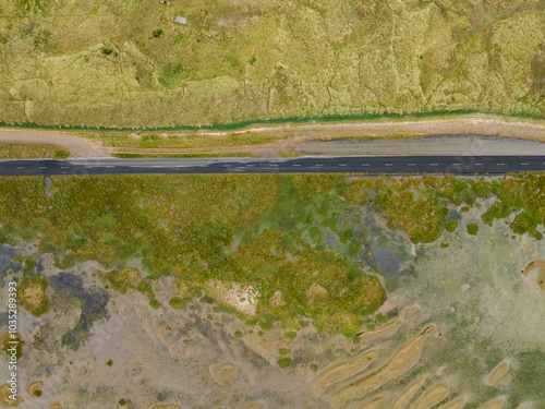 Aerial view of the serpentine holy island causeway surrounded by beautiful wetlands and greenery, Berwick-upon-Tweed, United Kingdom. photo