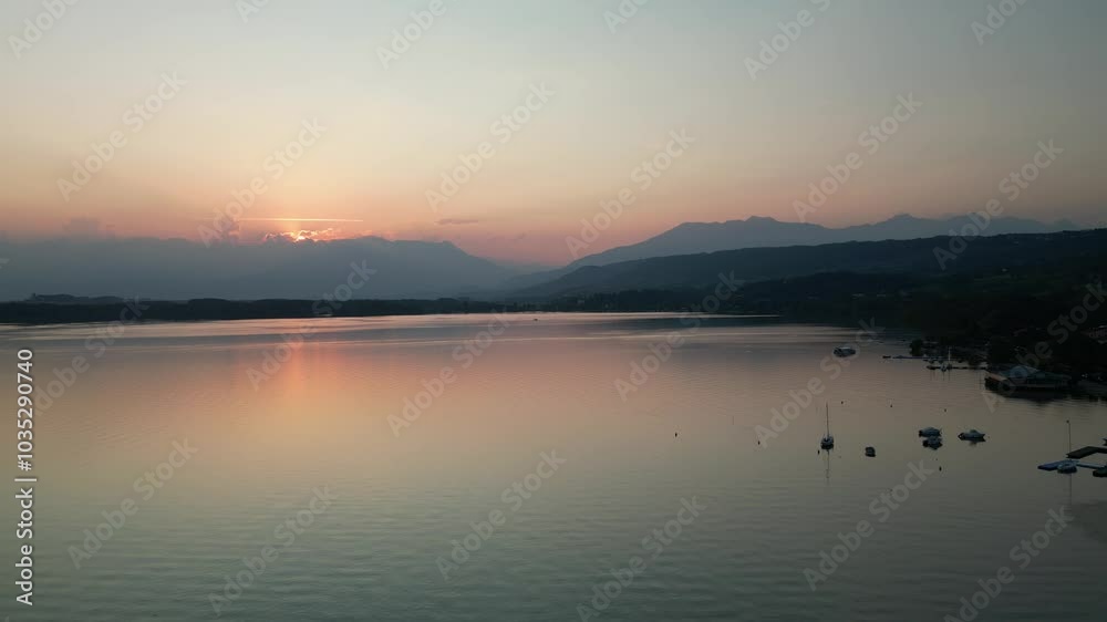 Aerial view of tranquil Lago di Viverone at sunset with serene reflections and picturesque mountains, Viverone, Italy. Aerial view of tranquil Lago di Viverone at sunset with serene reflections and picturesque mountains, Viverone, Italy.