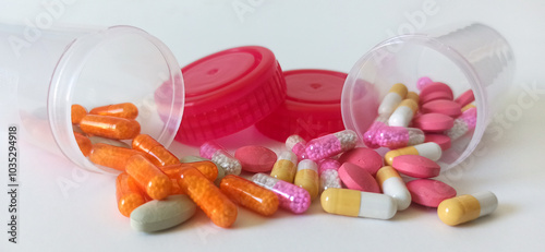 Pill capsules spill out of two plastic containers across a clean white surface to represent pharmaceutical distribution and healthcare management.