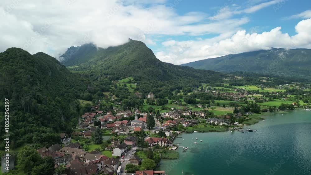 Aerial view of Chateau de Duingt on Lake Annecy surrounded by serene mountains and picturesque village, Duingt, France.
