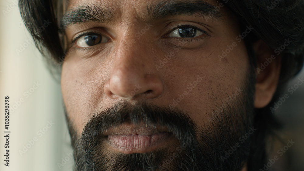 Obraz premium Close-up ethnicity male face serious pensive bearded indian man guy ethnic businessman customer looking at camera gaze with brown eyes client ophthalmology clinic good healthy vision medical procedure