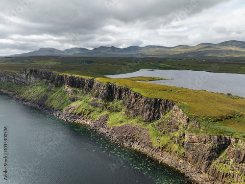 Aerial view of Kilt Rock Waterfall cascading down a cliff into the coastline, Portree, United Kingdom. photo