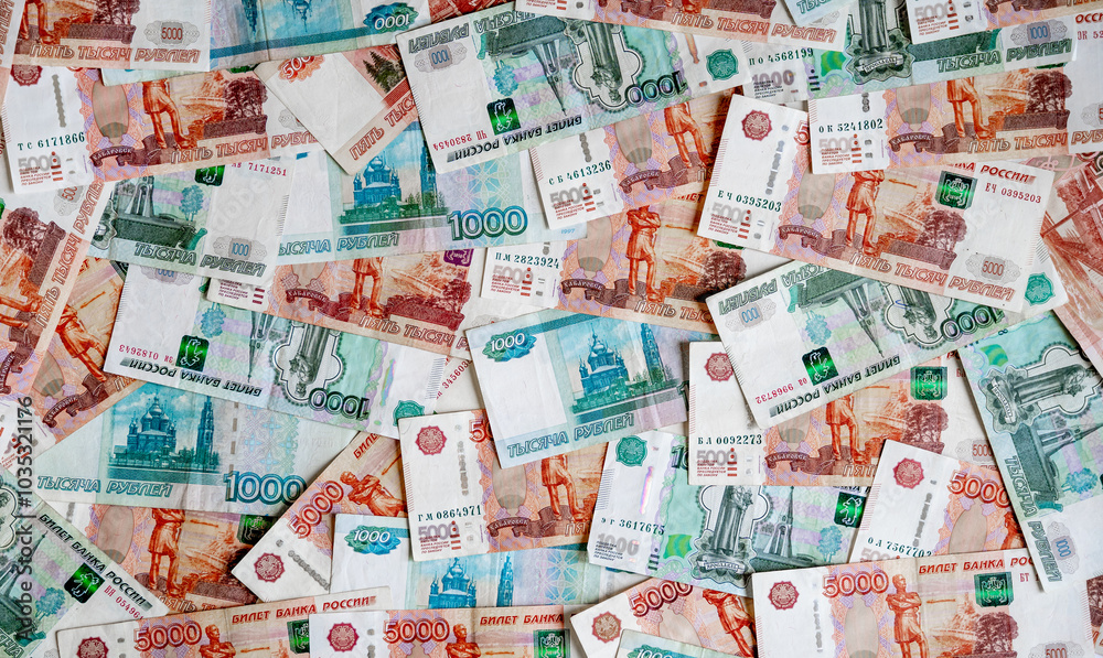 Russian money rubles in denominations of five thousand Russian rubles and one thousand Russian rubles are scattered all over the photograph, the background is made of money Russian money rubles in denominations of five thousand Russian rubles and one thousand Russian rubles are scattered all over the photograph, the background is made of money