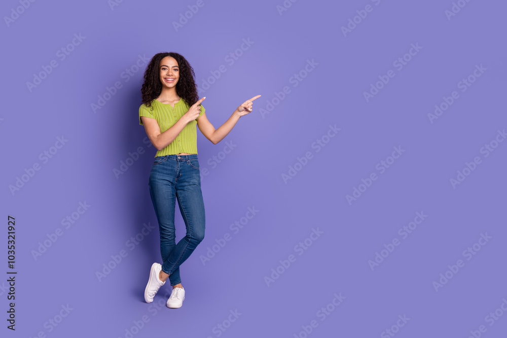 Full body photo of attractive teen woman point empty space dressed stylish green clothes isolated on purple color background Full body photo of attractive teen woman point empty space dressed stylish green clothes isolated on purple color background