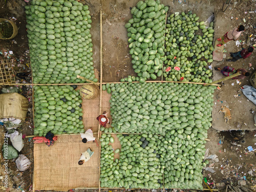 Aerial view of a vibrant street market bustling with people selling fresh watermelons, Dhaka Kotwali Thana, Bangladesh. photo