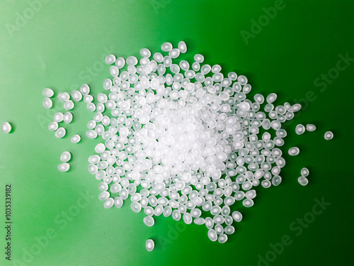 Virgin polypropylene plastic granules on a green background, this polymer is one of the main ingredients in the food grade plastic industry. photo