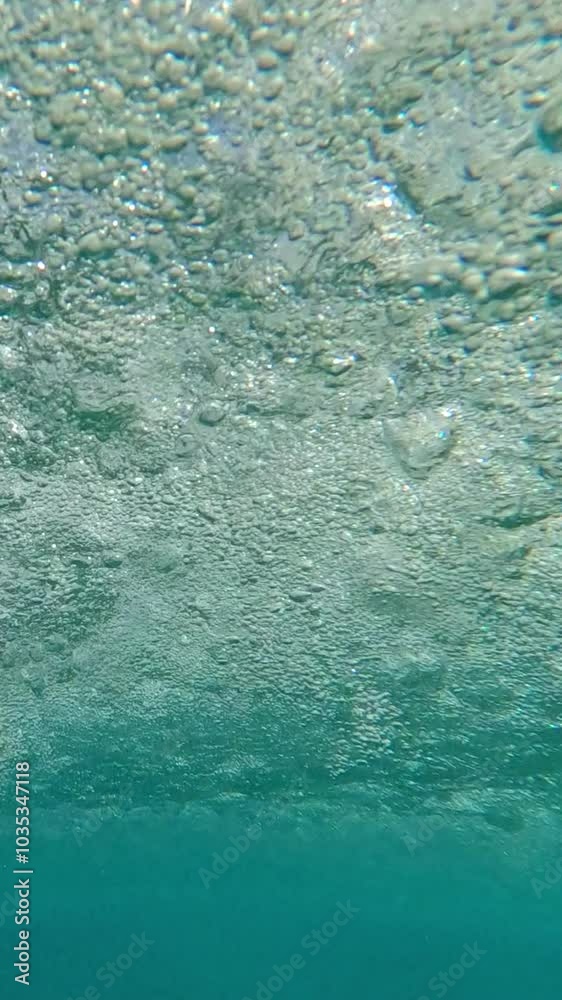 Vertical video, Bottom view of the water surface under a torrential tropical downpour, close-up, underwater shot Vertical video, Bottom view of the water surface under a torrential tropical downpour, close-up, underwater shot