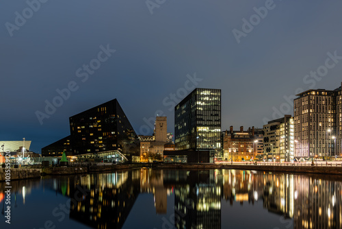 The modern buildings of liverpool are reflecting in the water of the docks photo