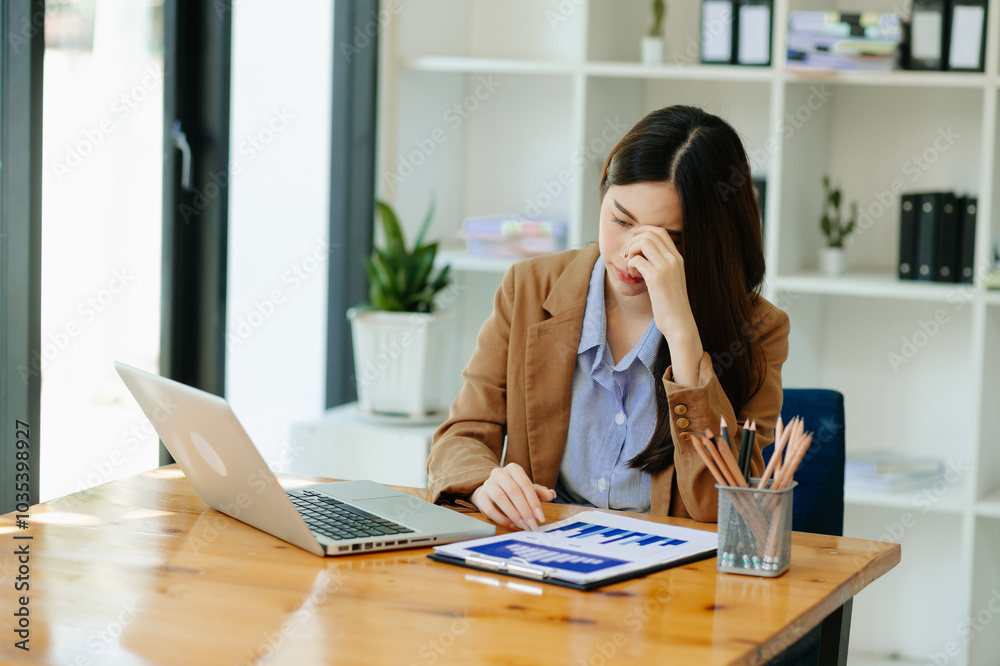 Woman who is tired and overthinking from working with tablet and laptop at modern office... Woman who is tired and overthinking from working with tablet and laptop at modern office...
