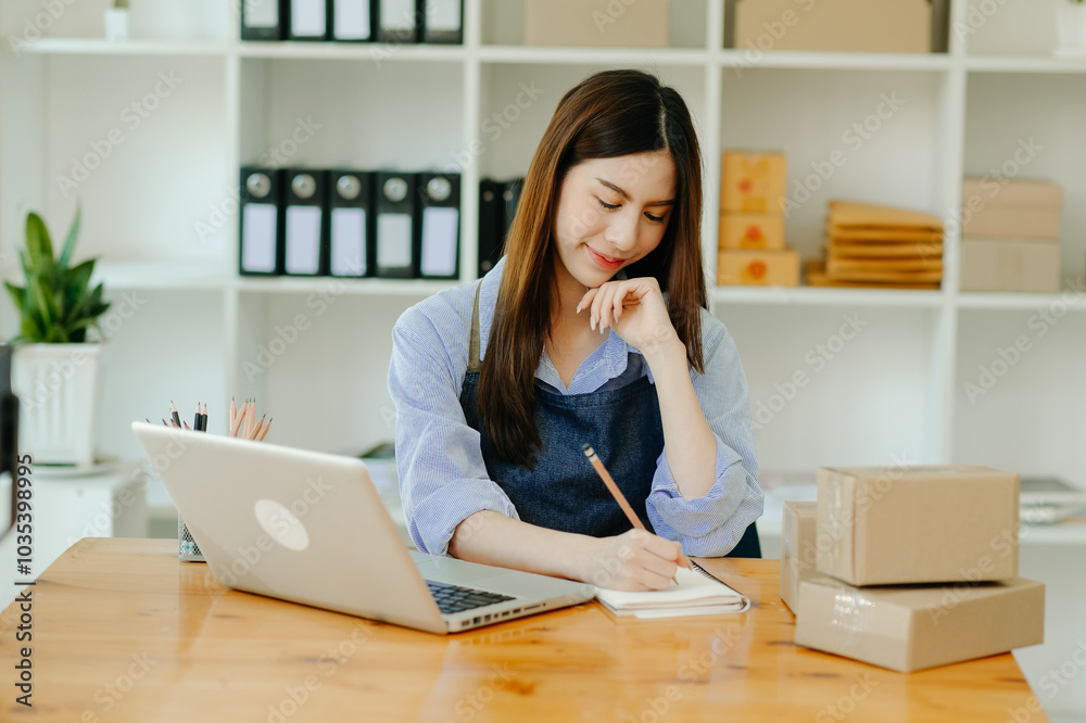 Young businesswoman managing online sales and shipping from a modern home office. Young businesswoman managing online sales and shipping from a modern home office.