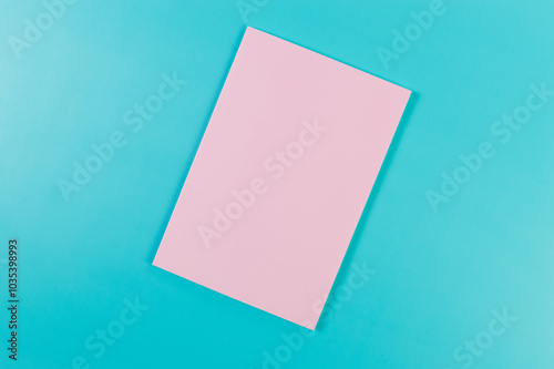 Top view of pink notebook on blue background. School, office wallpaper. Flat lay, copy space.