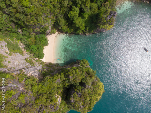 Fotografie A secluded beach surrounded by lush greenery and crystal-clear waters